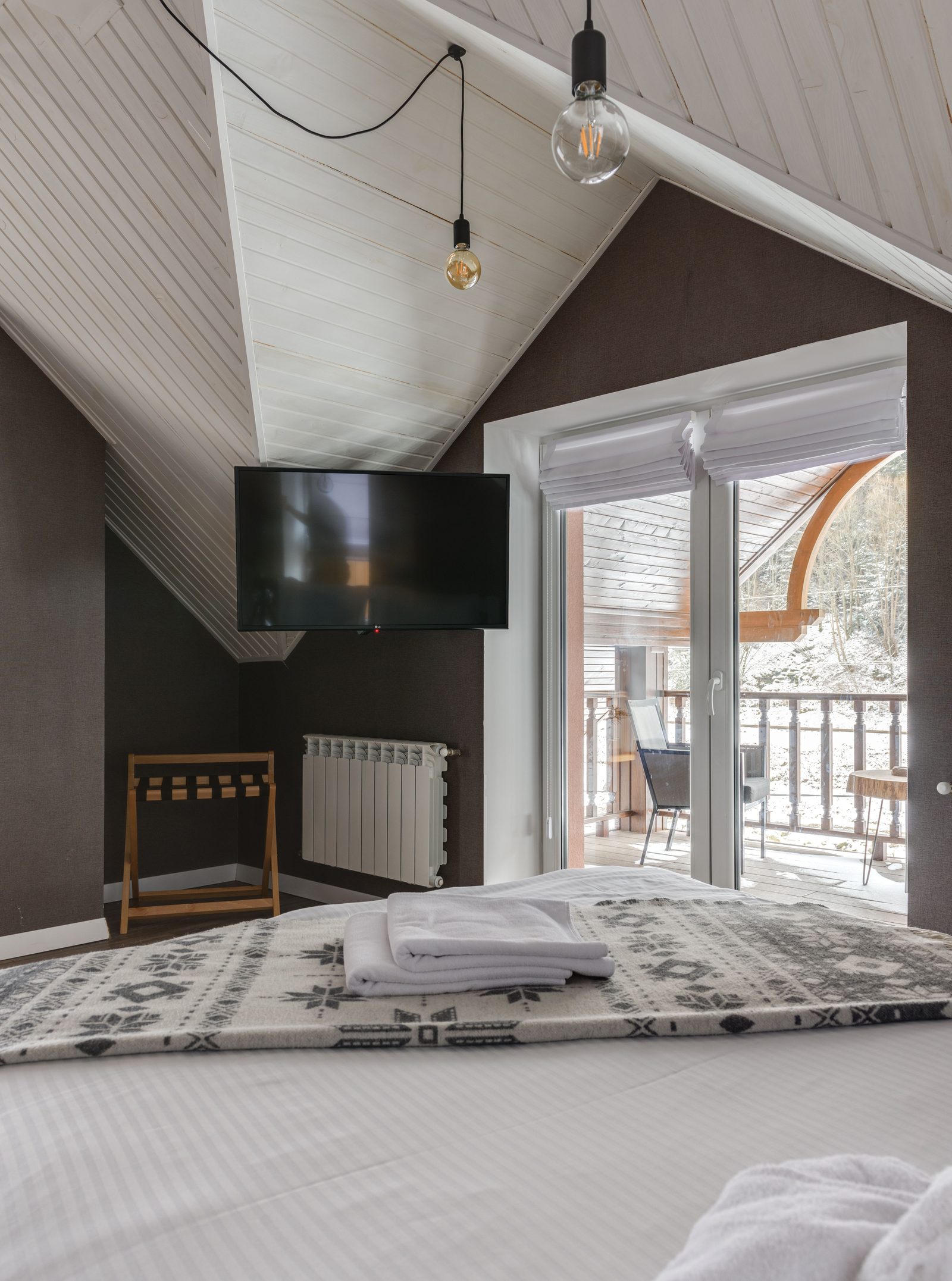 Attic room with boarded floor and balcony used for storage