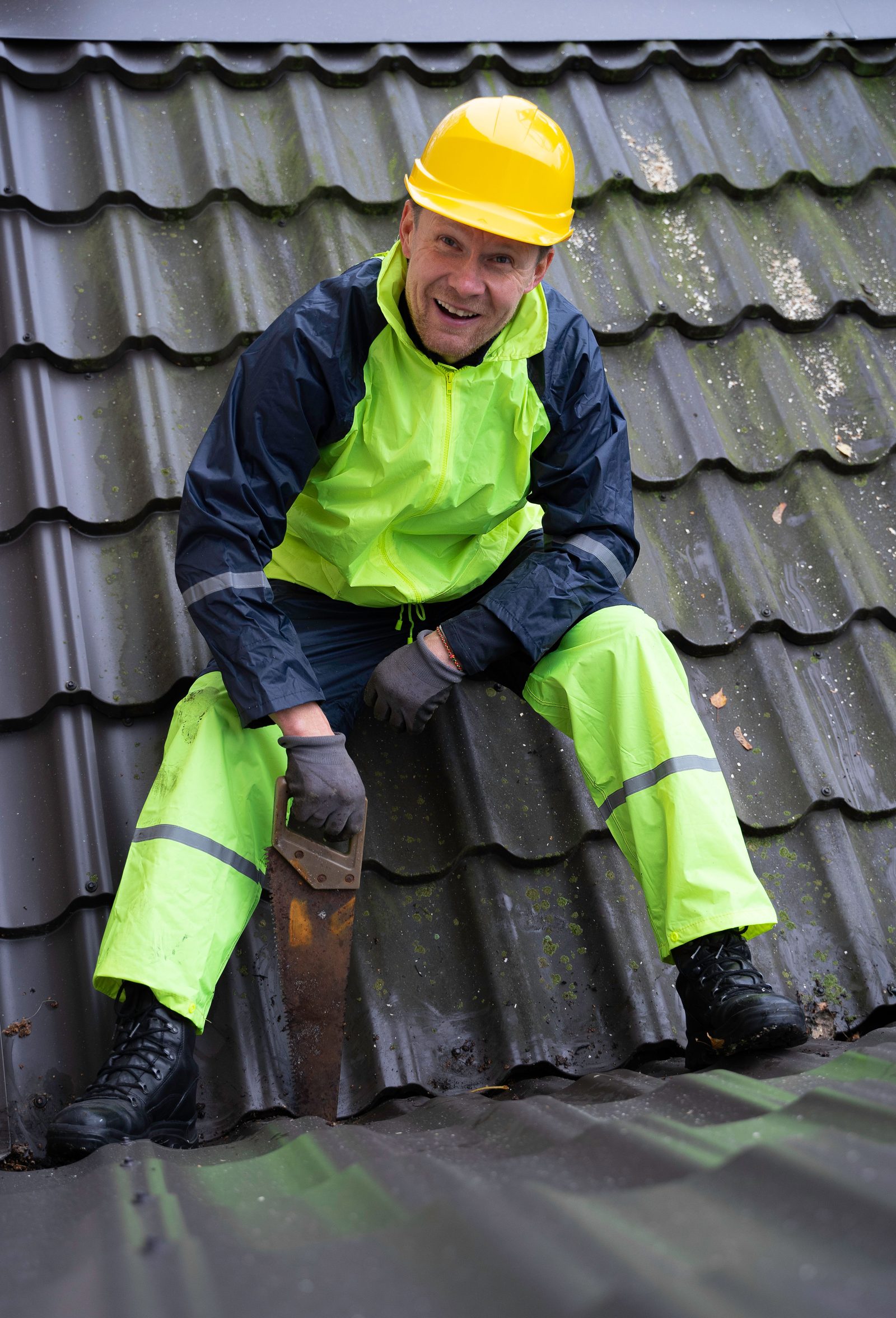 Roofer in hi-vis working on a house roof during a hip to gable conversion